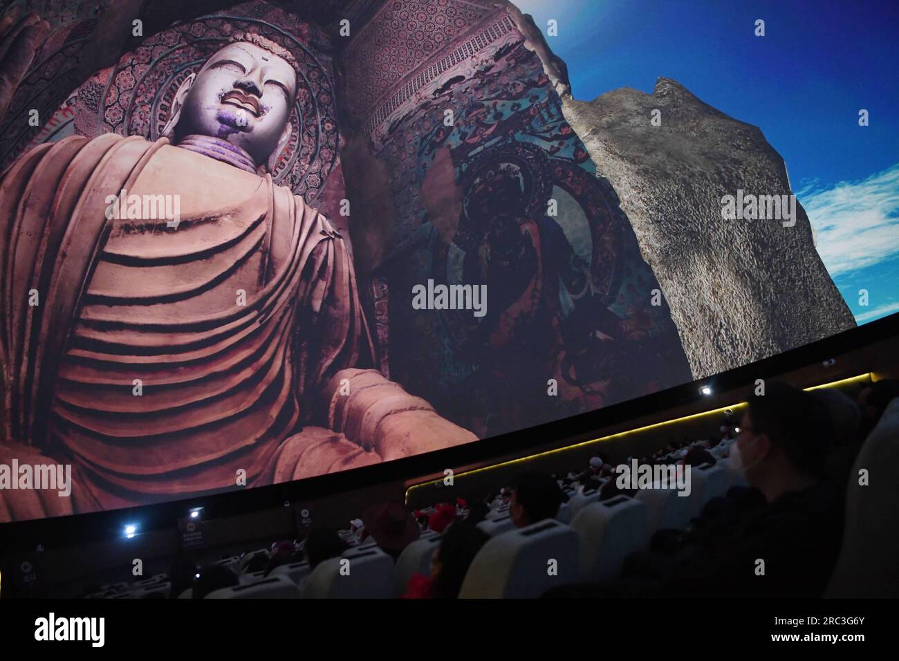 (230712) -- LANZHOU, 12. Juli 2023 (Xinhua) -- Menschen sehen einen vollständigen digitalen Film in einem digitalen Zentrum in Dunhuang, Nordwestchina, Provinz Gansu, 14. März 2023. (Xinhua/Chen Bin) Stockfoto