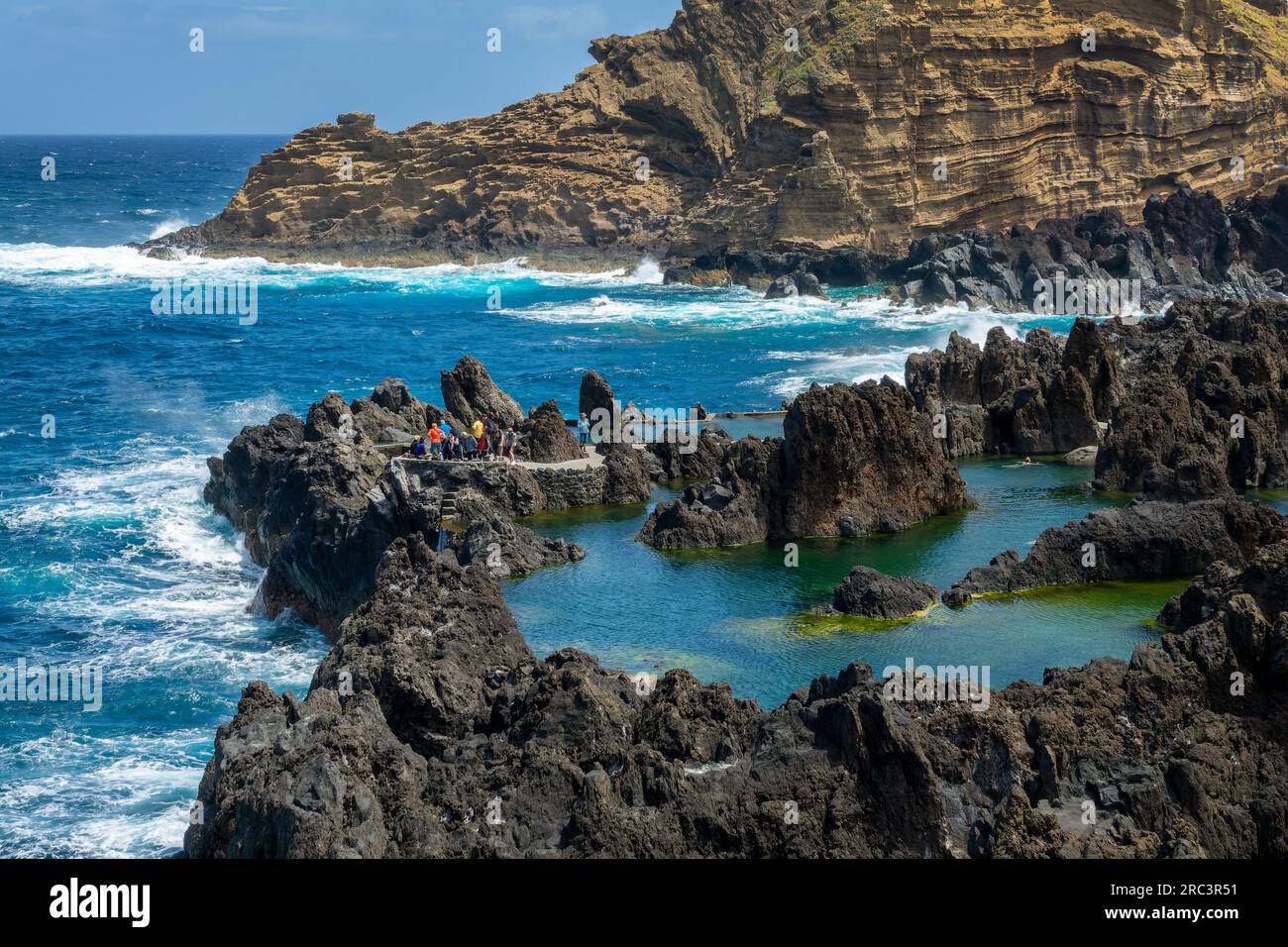 Touristen besuchen die natürlichen Meerwasser-Lava-Pools in Porto Moniz, Madeira, Portugal Stockfoto