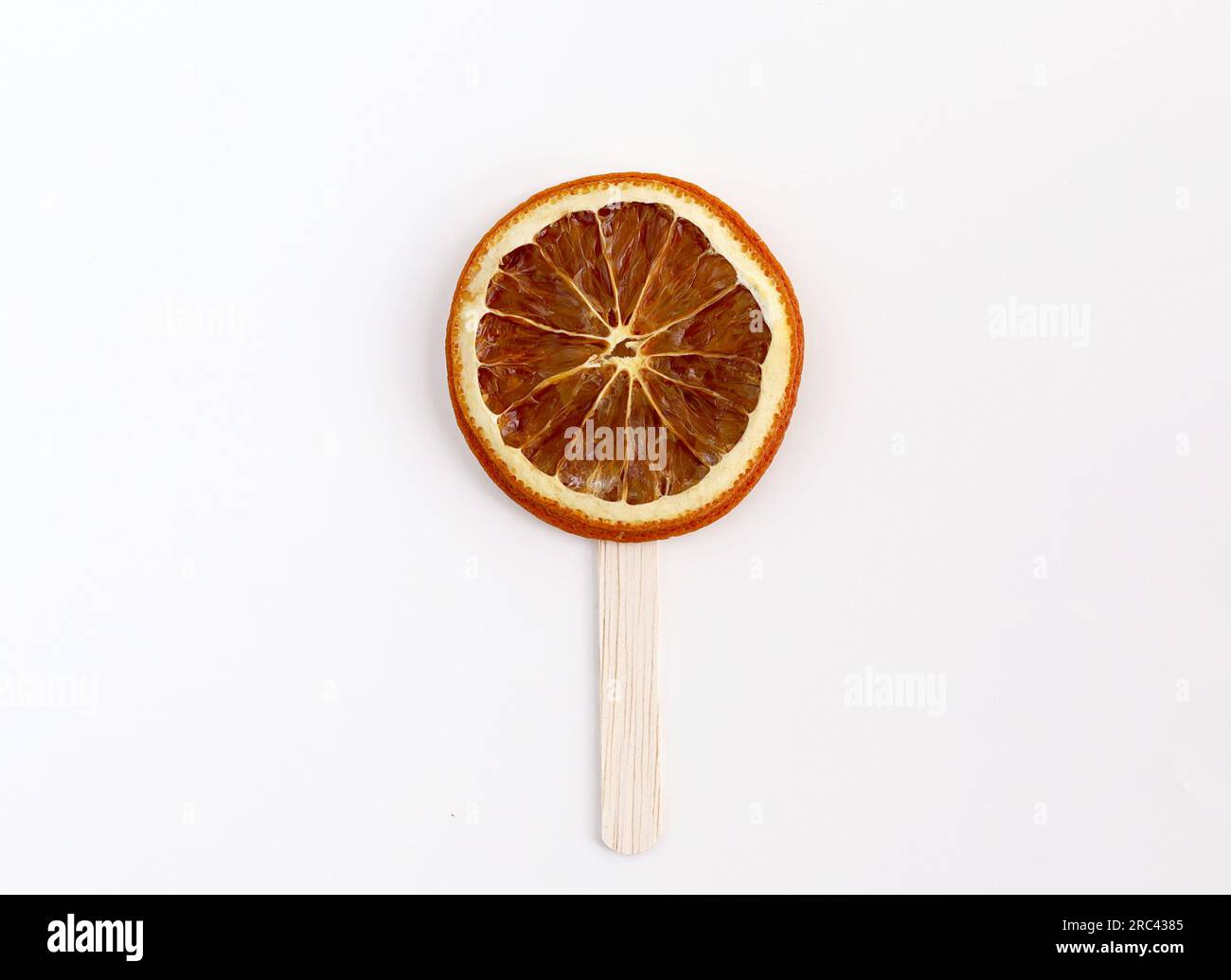 Orangenscheiben mit Eisstäbchen, isoliert auf weißem Hintergrund. Konzeptbild von Lollipop-Süßigkeiten oder Eiscreme Stockfoto