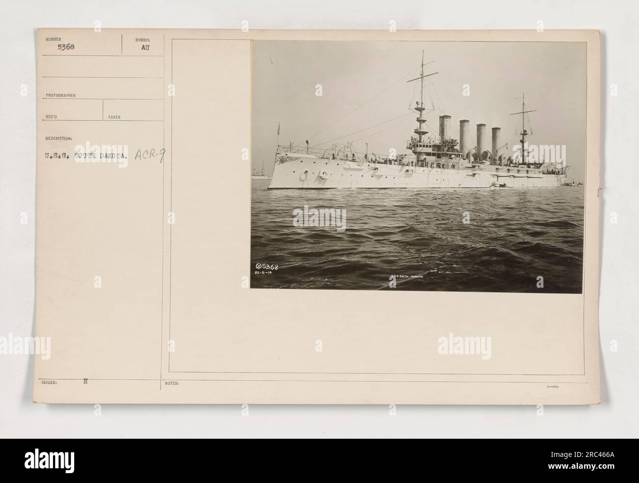 Soldaten in Uniformen stehen auf dem Deck der U.S.S. South Dakota im Ersten Weltkrieg. Das als ACR-9 gekennzeichnete Schiff ist deutlich im Hintergrund zu sehen. Das Foto scheint von einem Fotografen mit den Initialen RECO aufgenommen worden zu sein. Stockfoto