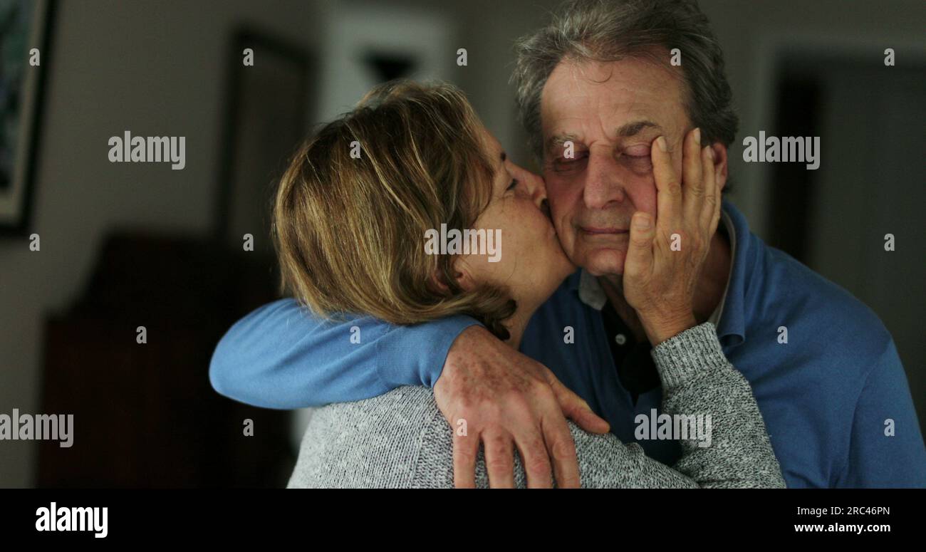 Seniorenfrau küsst Ehemann älteres Paar Liebe und Zuneigung Stockfoto
