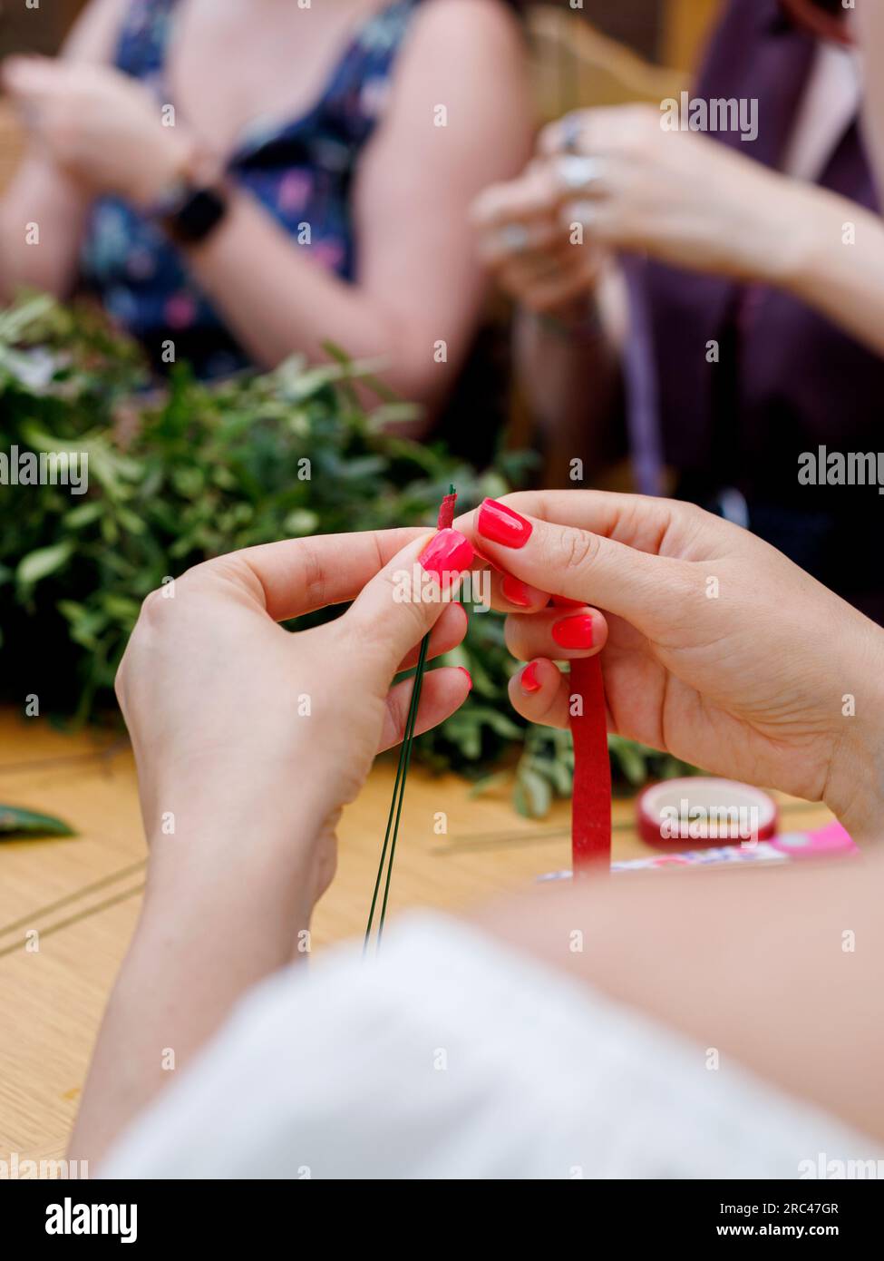 Eine wunderschöne Floristin führt eine Meisterklasse über ihre Kunst im serbischen Nationaldorf durch Stockfoto