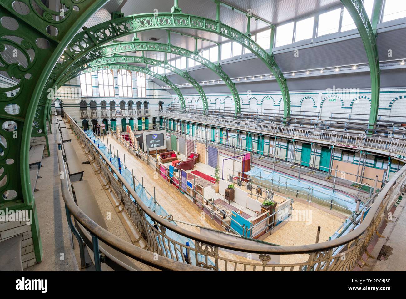 Birmingham, Großbritannien. 12. Juli 2023. Ein Swimmingpool aus dem Jahr 1907 ist die Heimat einer vorübergehenden Umwandlung in ein Wohnzimmer. Das Balsall Heath Gala Pool in der Innenstadt von Balsall Heath, Birmingham, bietet Kunstwerke, Teppiche und weiche Möbel, die einen willkommenen Ort für eine Tasse Tee und ein Gespräch bieten. Die Bäder der Moseley Road werden zur gleichen Zeit renoviert, um ihre edwardianischen Armaturen und Armaturen zu präsentieren. Kredit: Peter Lopeman/Alamy Live News Stockfoto