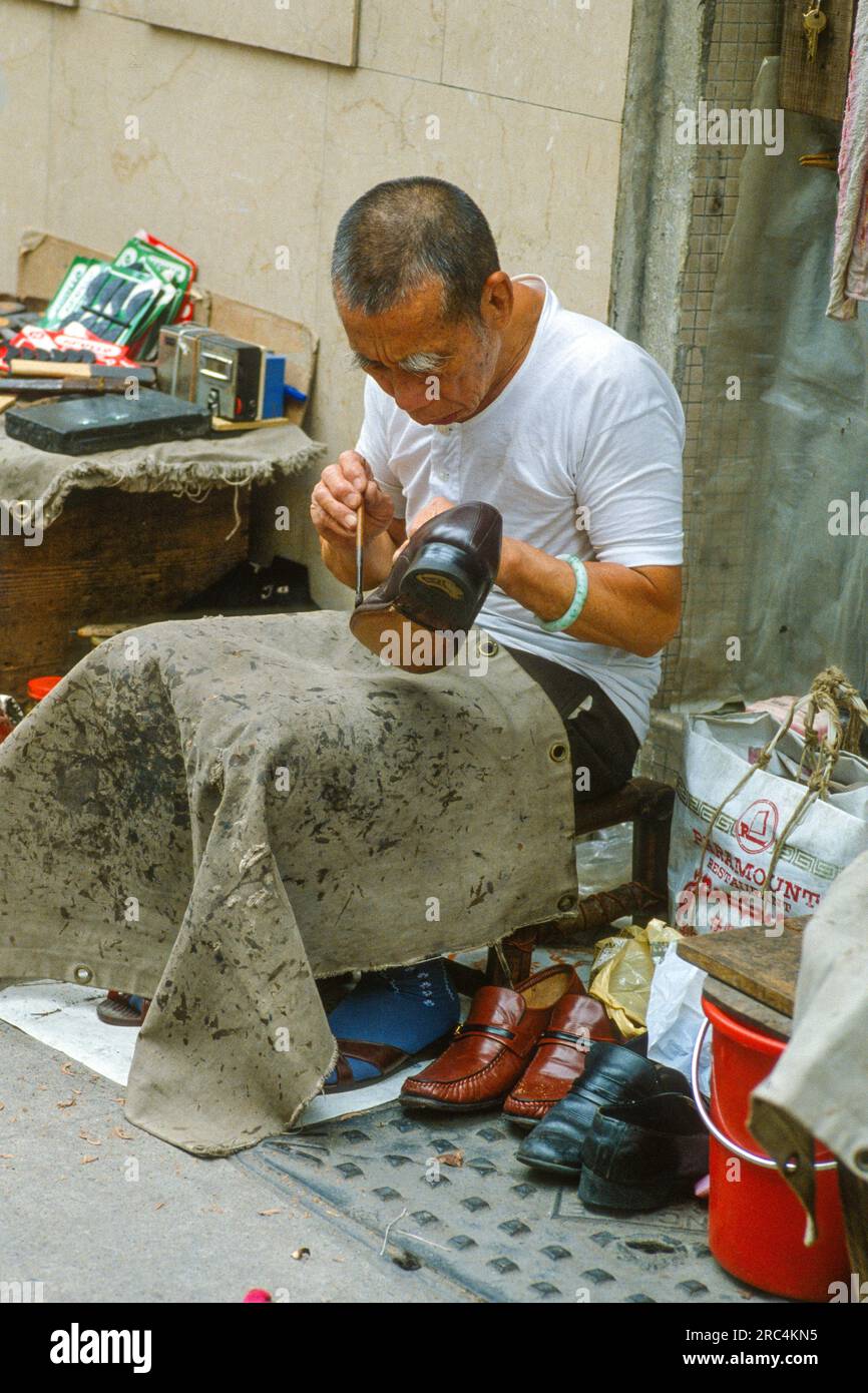 Mann repariert Schuhe in Hong Kong Backstreet, Hong Kong, Hong Kong Special Administrative Region der Volksrepublik China Stockfoto