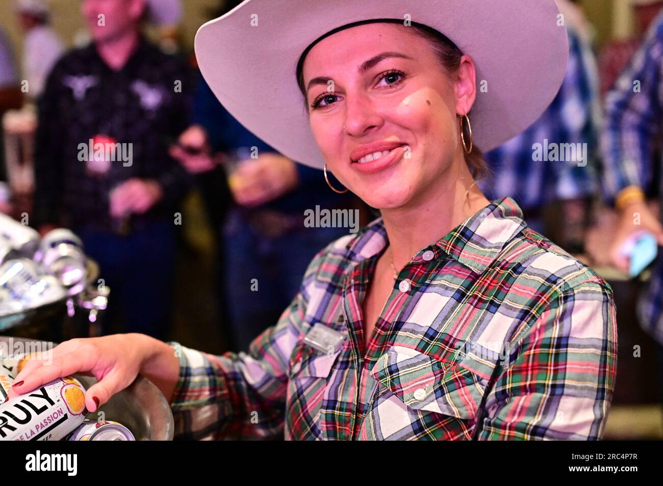 Junge Kellnerin trägt einen Cowboyhut beim Calgary Stempede Bootleggin Breakfast, Juli 2023. Stockfoto