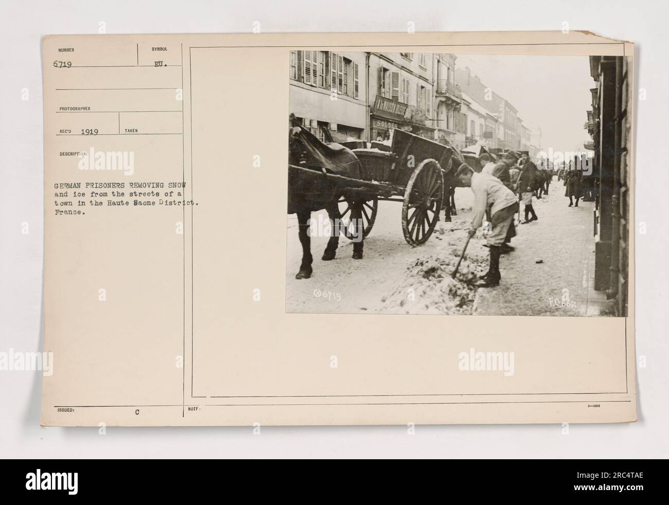 Deutsche Kriegsgefangene entfernen Schnee und Eis von den Straßen einer Stadt im französischen Bezirk Haute Saone im Jahr 1919. Diese Aktivität war Teil ihrer täglichen Arbeitsroutine, die darauf abzielte, die Monotonie des Lagerlebens für die Gefangenen zu brechen. Stockfoto