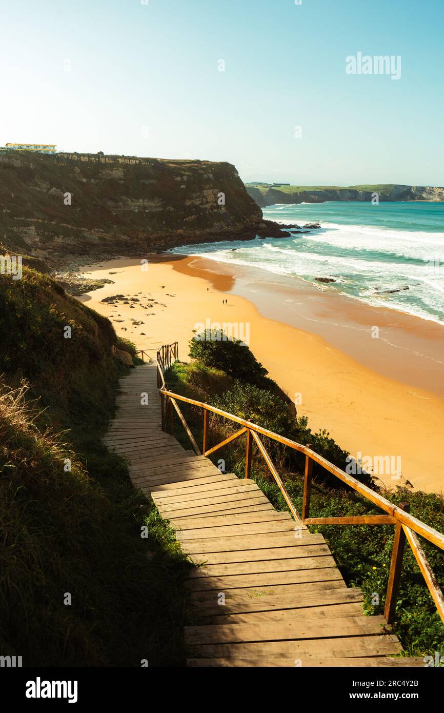 Von oben über einem hölzernen Pier mit Geländern und Sandstrand in der Nähe des Wellenmeers bei klarem Wetter im Hintergrund bei wunderschönen Naturausflügen Stockfoto