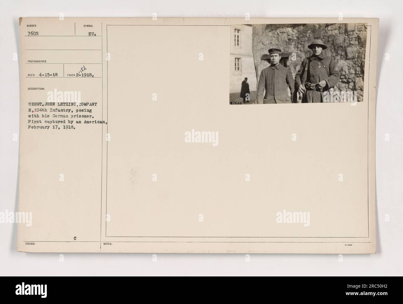 Sergeant John Letzing von Kompanie E, 104. Infanterie, ist auf diesem Foto zu sehen, das im Februar 1918 während des Ersten Weltkriegs aufgenommen wurde. Er posiert mit einem gefangenen deutschen Soldaten, was auf eine erfolgreiche Gefangennahme durch einen amerikanischen Soldaten hindeutet. Die spezifischen Details zum Fotografen, Symbole und Daten sind in den Notizen enthalten. Stockfoto