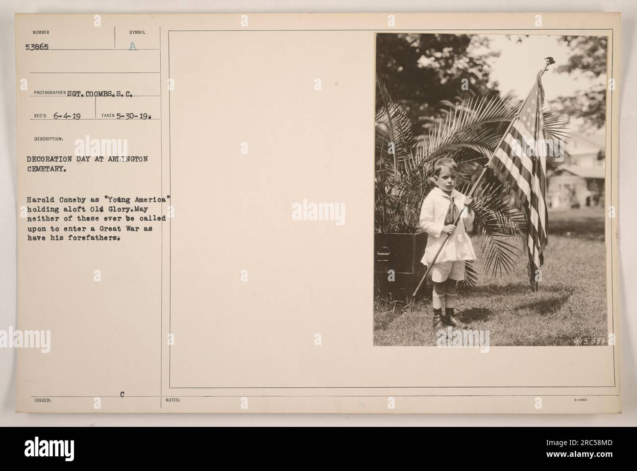 Harold Coneby, verkleidet als „Junges Amerika“, mit einer Flagge am Tag der Dekoration auf dem Arlington Cemetery. Das Foto, das Sergeant Coombs am 30. Mai 1919 aufgenommen hat, zeigt einen feierlichen Moment der Erinnerung und die Hoffnung, dass weder das junge Amerika noch die Flagge in einen weiteren Krieg verwickelt werden. (50 Wörter) Stockfoto