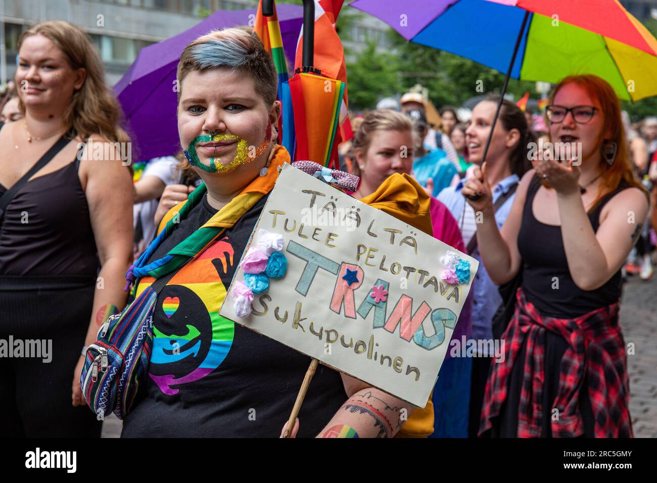 Tääluti tulee pelottava transsukupuolinen. Teilnehmer mit einem selbst gemachten Schild bei der Helsinki Pride 2023 Parade in Helsinki, Finnland. Stockfoto