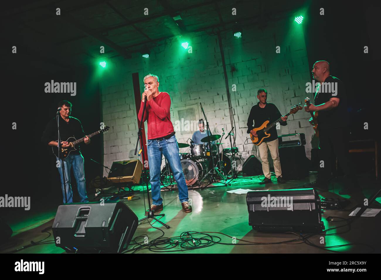 Die Punk-Rock-Band-Gruppe gibt Live-Auftritte auf einer Bühne. Sängerkünstler, Bass- und E-Gitarrenmusiker und Schlagzeuger Stockfoto
