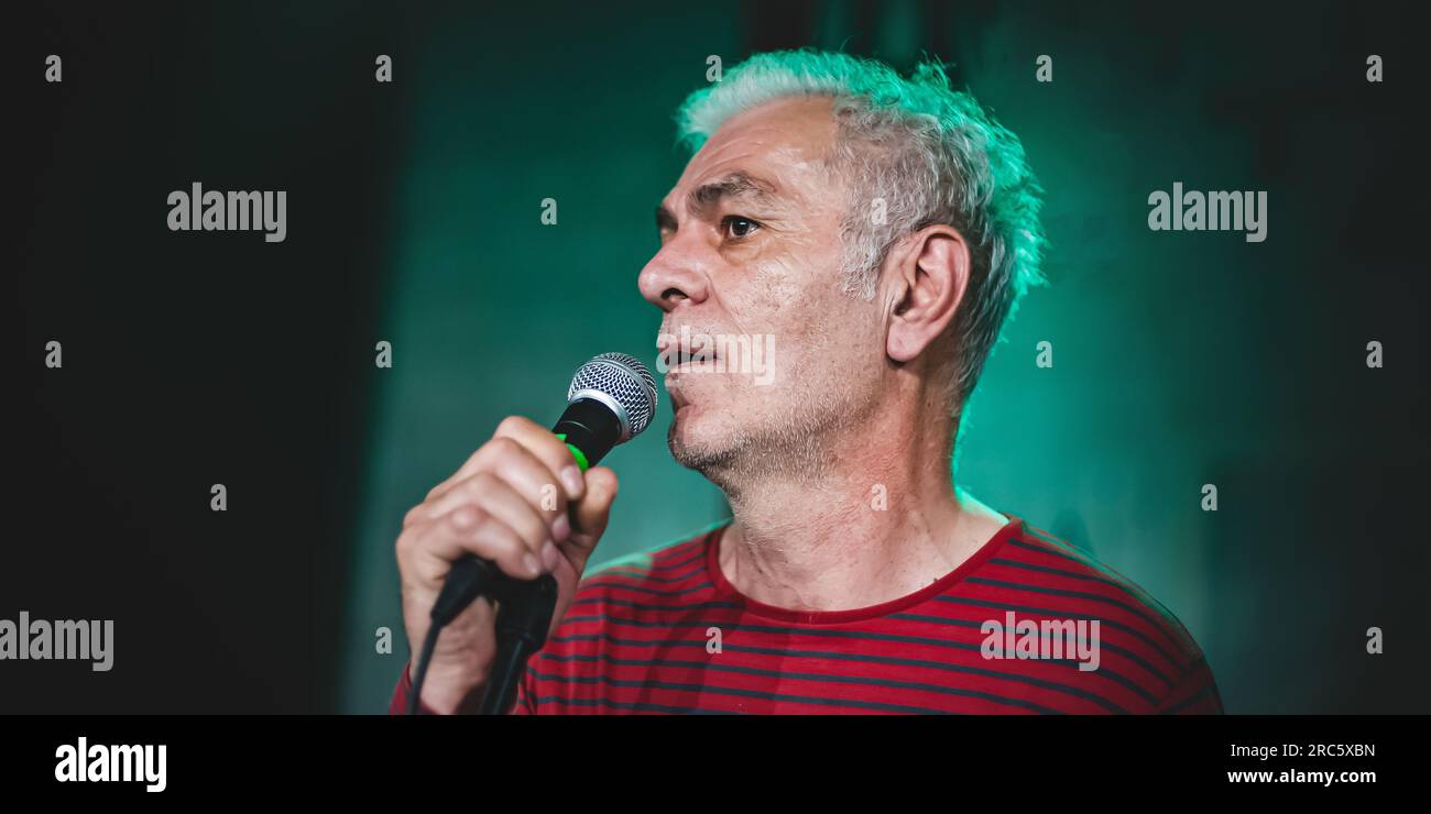 Nahaufnahme eines Stehdarsteller-Komikers auf der Bühne, der in ein Mikrofon spricht und singt Stockfoto