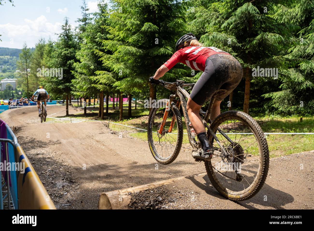 Malene Deng jagt Emeline Detilleux und springt über die Baumstämme - UEC MTB Elite Europameisterschaft 2023 - Europaspiele - Krakau/Kraków - Krynica-Zdrój Stockfoto