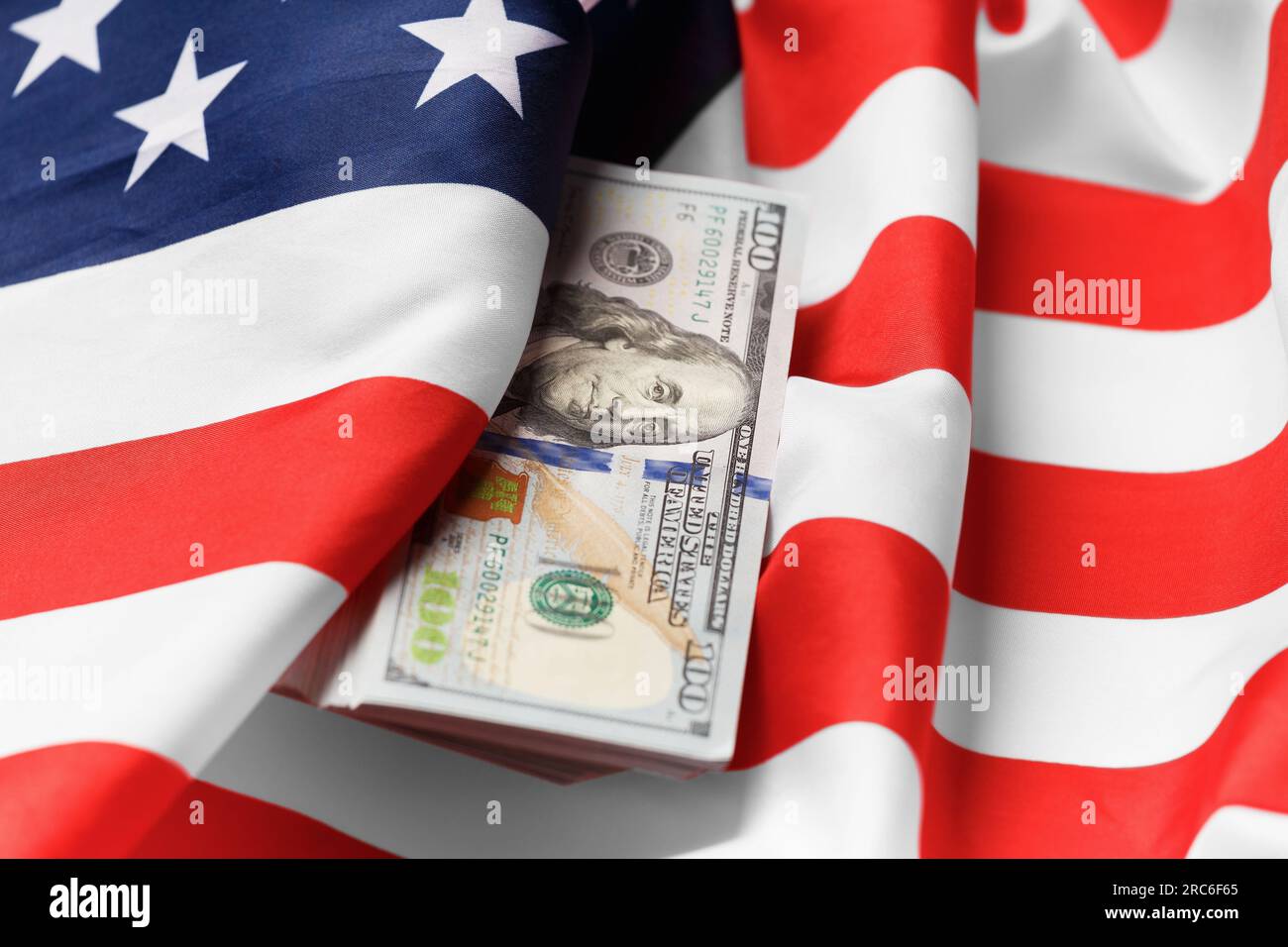 Amerikanische Nationalflagge und Hundert-Dollar-Scheine. Das Konzept von Wirtschaft, Finanzen, Wirtschaft, internationaler Währung. Stockfoto