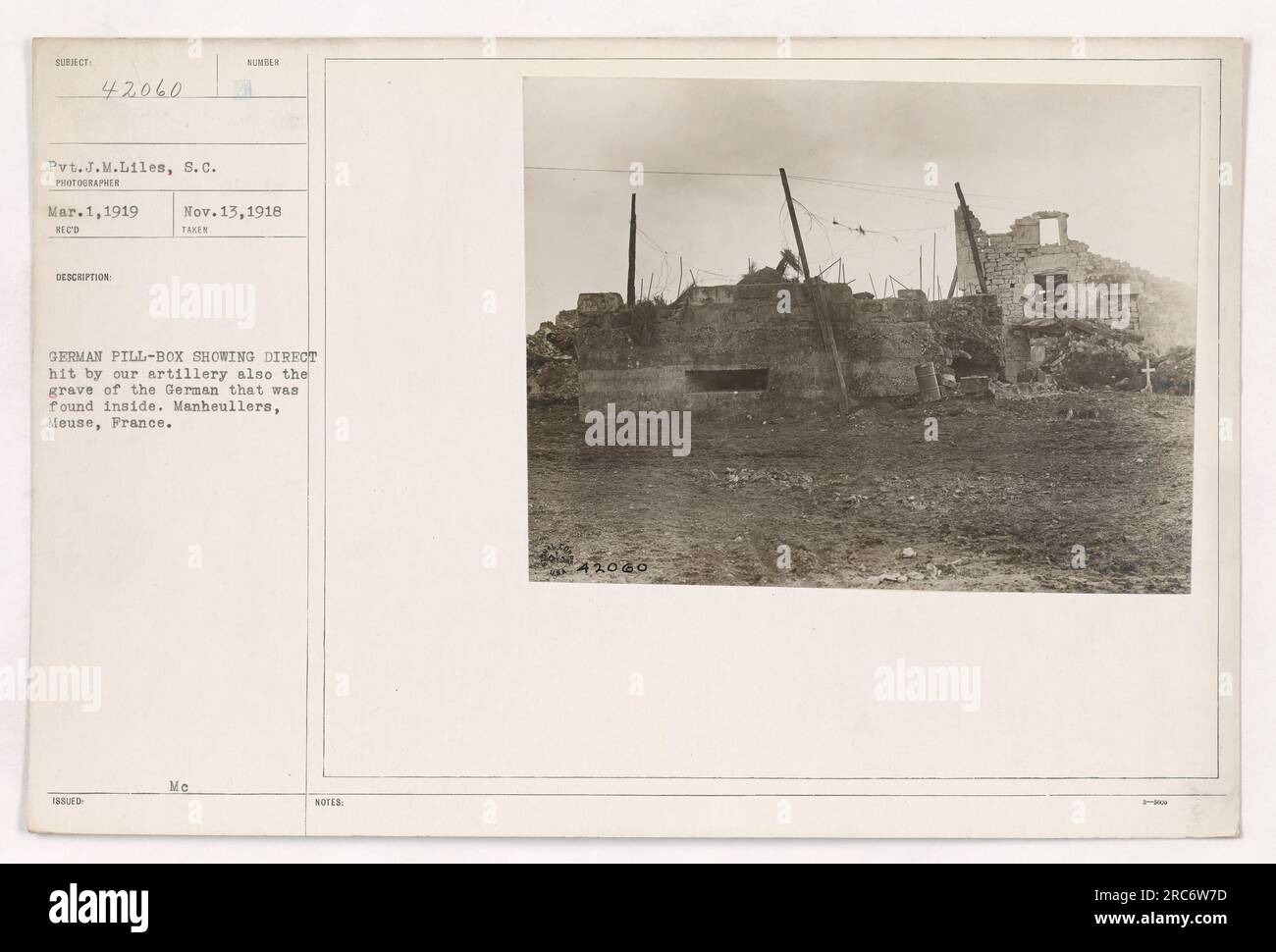 Pvt. J.M. Liles, S.C. steht neben einer deutschen Pillenschachtel, die direkt von unserer Artillerie getroffen wurde. Das Foto zeigt auch das Grab eines deutschen Soldaten, der darin gefunden wurde. Standort: Manheullers, Maas, Frankreich. Bild Nummer 42060. Aufgenommen am 1. März 1919 von einem nicht identifizierten Fotografen. Diese Angaben sind auch in Anmerkung Nr. 42060 erfasst. Stockfoto