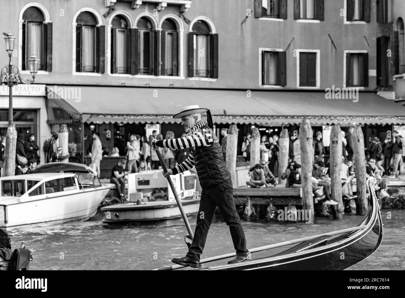 Venedig, Italien - 2. April 2022: Älterer Gondoliere mit traditionellem Strohhut und blauem Band in Venedig, Italien. Stockfoto