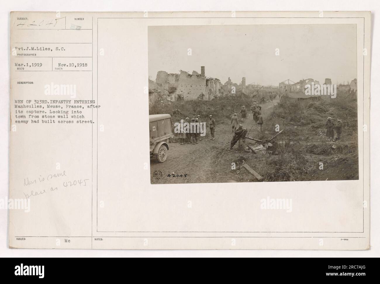 Pvt. J.M. Liles, S.C., fotografiert am 1. März 1919, nahm das Bild von Männern der 323. Infanterie auf, die Manheulles, Maas, Frankreich, betreten. Das Foto zeigt die Aussicht von einer Steinmauer, die der Feind auf der anderen Straßenseite errichtet hatte. Ähnlich wie Bild 42045 Me.“ Stockfoto