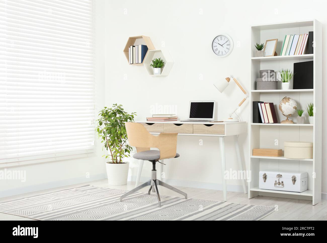 Schöner Arbeitsplatz mit komfortablem Schreibtisch und Stuhl zu Hause Stockfoto