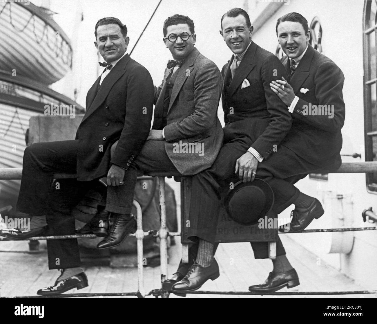 Mai 1925, vier Männer sitzen auf dem Geländer der S.S. Olympic, wie es aus Europa in New York eintrifft. Von links sind Archie Selwyn und Harry Green. Stockfoto