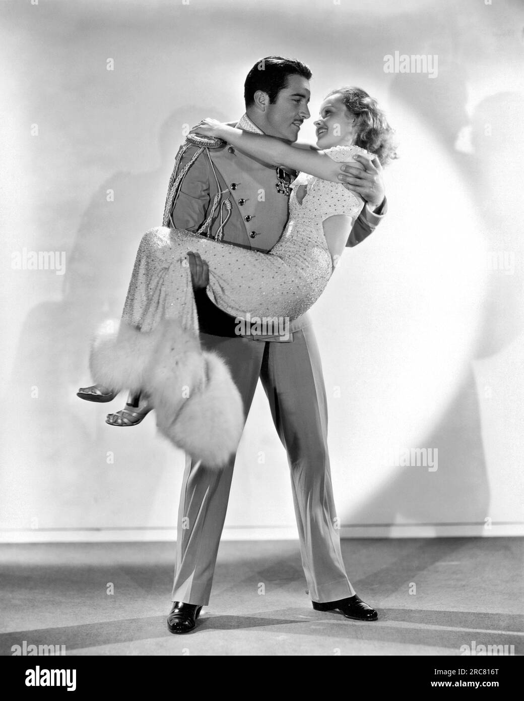 Hollywood, Kalifornien: 1933. John Boles hebt die reizende Lilian Harvey in dem Film "Meine Lippen verraten" auf. Stockfoto