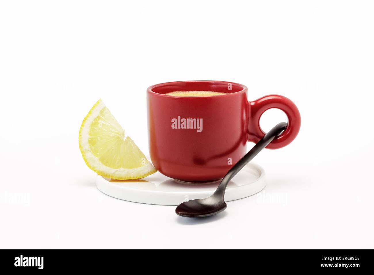 Rote Tasse gefüllt mit starkem Kaffee und einer Scheibe Zitrone, natürliches Kopfschmerzmittel Stockfoto