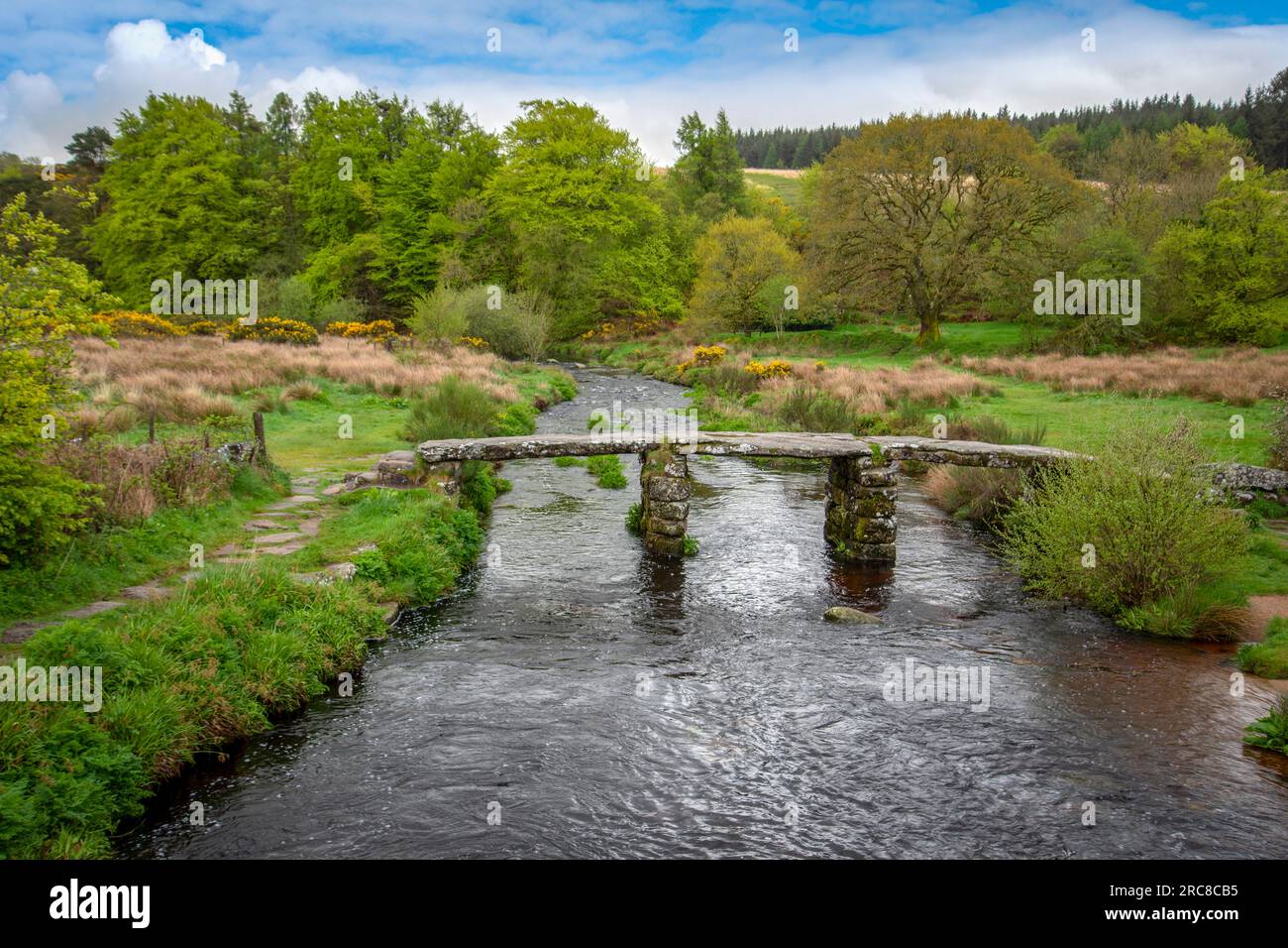 Alte mittelalterliche Klapperbrücke, die sich über den östlichen Dart-Fluss Postbridge dartmoor erstreckt. Die Brücke besteht aus zwei zentralen Piers, die von drei großen gran gespannt sind Stockfoto