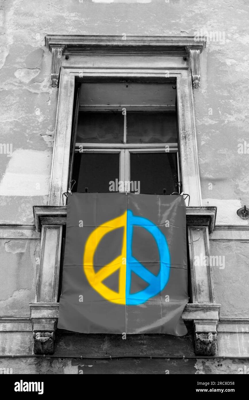 Die ukrainische Flagge hängt aus einem Fenster in Padua, Italien. Unterstützung des ukrainischen Volkes gegen den russischen Angriff. Stockfoto