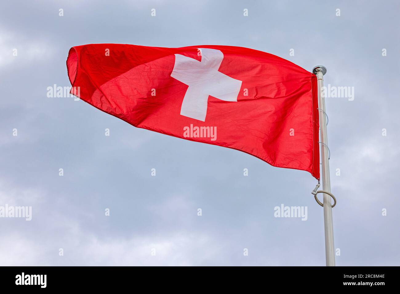 Leuchtend rote Flagge der Schweiz über Wolken Himmel Stockfoto