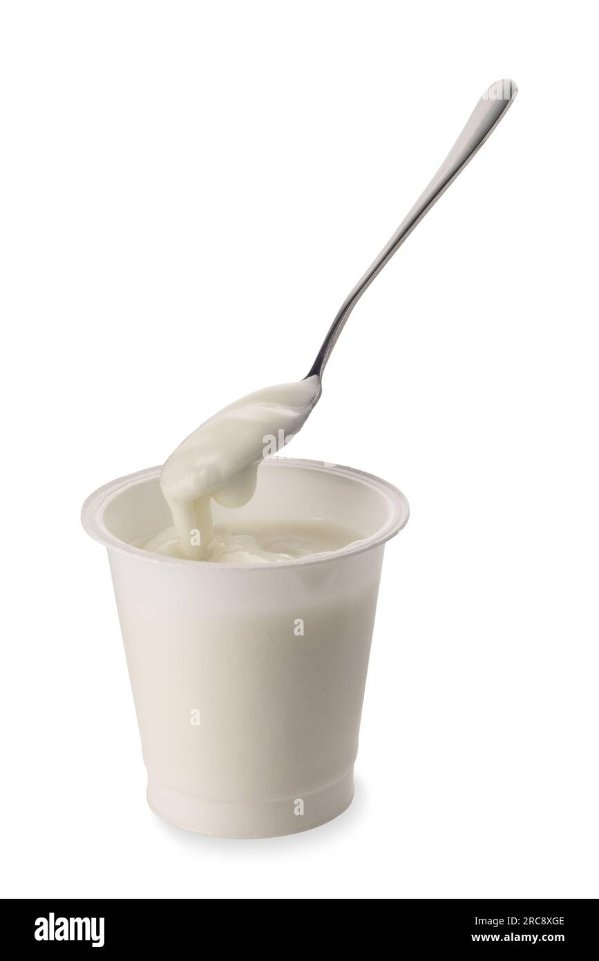 Weißer Joghurt in einem Kunststoffbehälter mit Teelöffel, der Joghurt auf weißem Boden isoliert mit Schneideweg aufnimmt Stockfoto