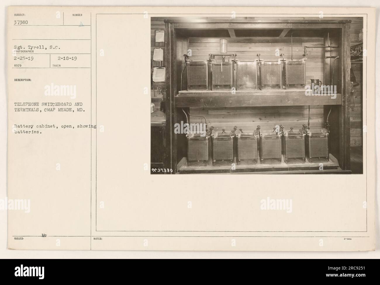 Abbildung eines offenen Batterieschranks mit den Batterien, die für die Telefonschalttafel und die Terminals in Camp Meade, MD, verwendet werden Sergeant Tyrell wird beim Umgang mit der Ausrüstung gesehen. Dieses Foto wurde am 25. Februar 1919 aufgenommen und am 18. Februar 1919 erhalten. Hinweise geben die Beschreibung und Nummer des Bildes an. Stockfoto