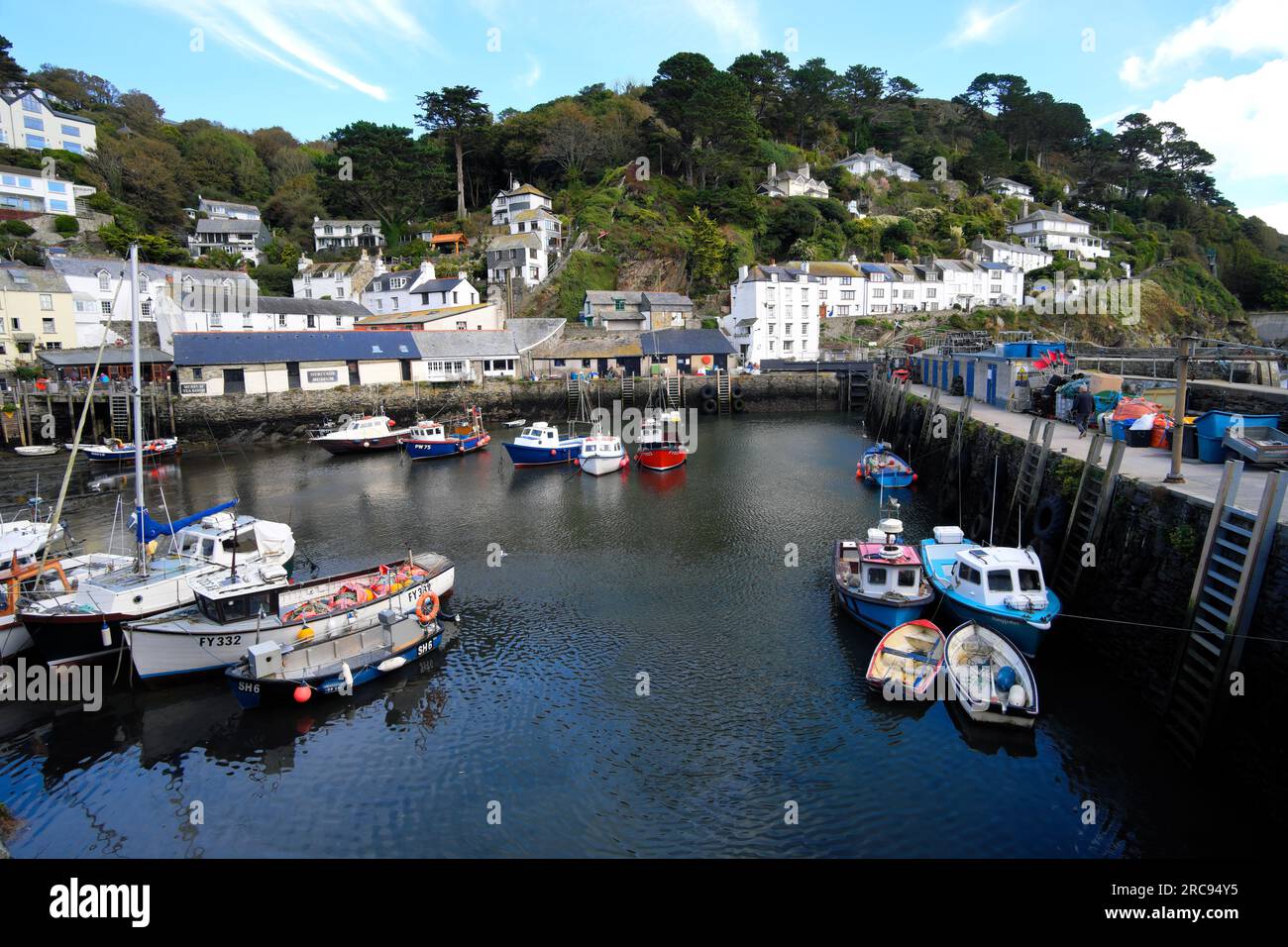 Boote und weiß getünchte Hütten im Hafen des typisch kornischen Fischerdorfes Polperro in Cornwall, England Stockfoto