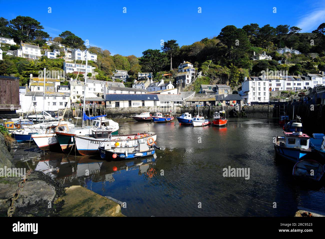 Boote und weiß getünchte Hütten im Hafen des typisch kornischen Fischerdorfes Polperro in Cornwall, England Stockfoto