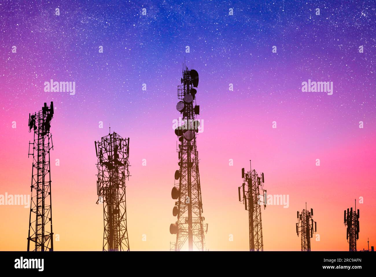 Kommunikationstürme am dunklen Himmel, die 4G- und 5G-Netzwerke mit Strom versorgen. Zellensilhouette des Variety Network vor dem leuchtenden Morgenhimmel. Stockfoto