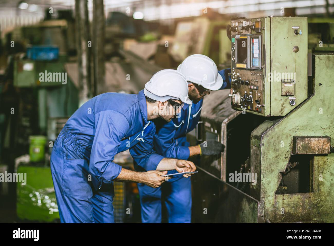 Wartungsteam des Werkes des Drehtechnikers prüft Wartung Fräskopf CNC-Maschine im Werk der Schwermetallindustrie Stockfoto
