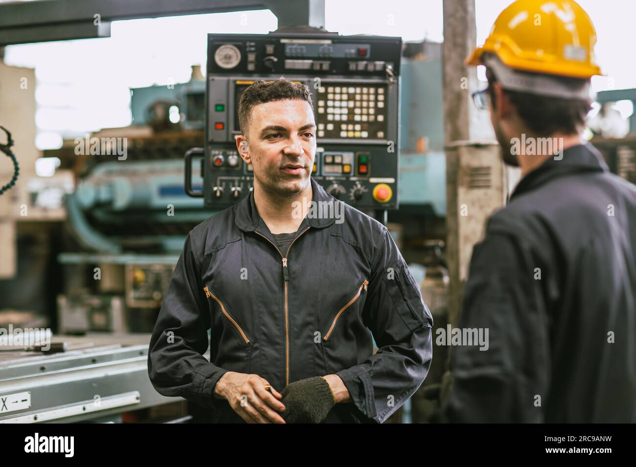 Junger Mitarbeiter des Technikers, der mit dem Vorgesetzten des Senior-Teams spricht, berät sich mit dem Problem, das bei der Arbeit auftritt Stockfoto