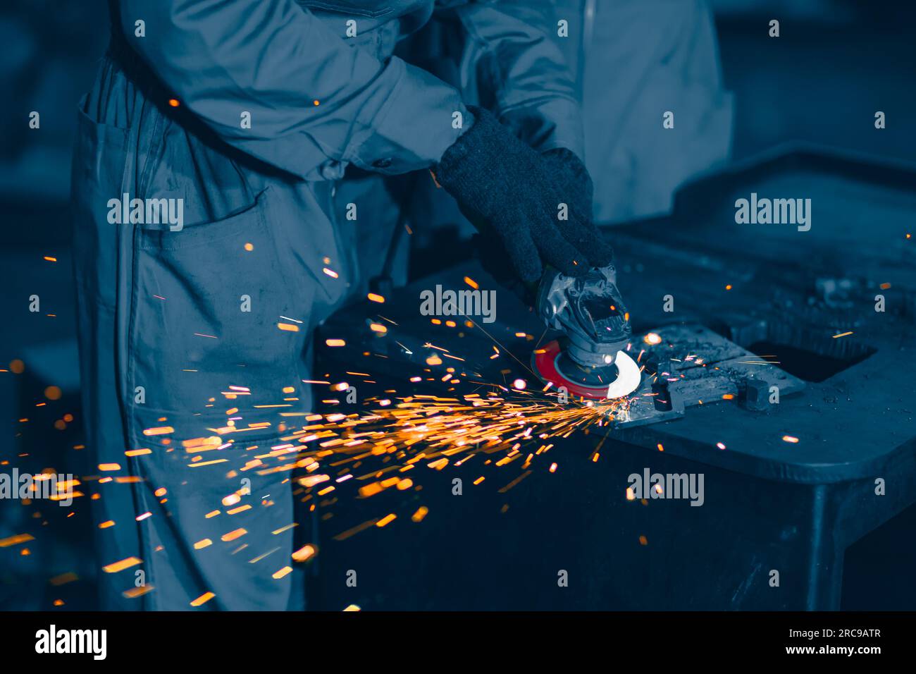 Industriearbeiter, der einen Winkelschleifer verwendet und eine Metallplatte schneidet. Grafik zur Schwermetallindustrie in der Fabrik für Werbung. Stockfoto