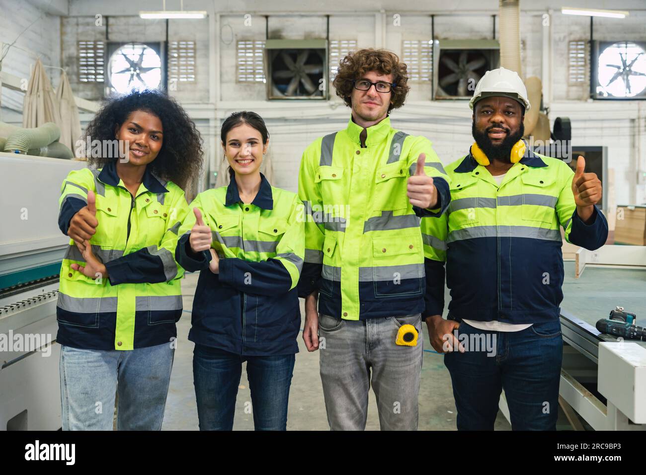 Professioneller Teamarbeiter feiert Erfolg in der Maschinenwerkstatt, fröhliche Arbeiter Gruppenporträt bei der Arbeit, Glück fair, gute Arbeit, Erfolg Stockfoto