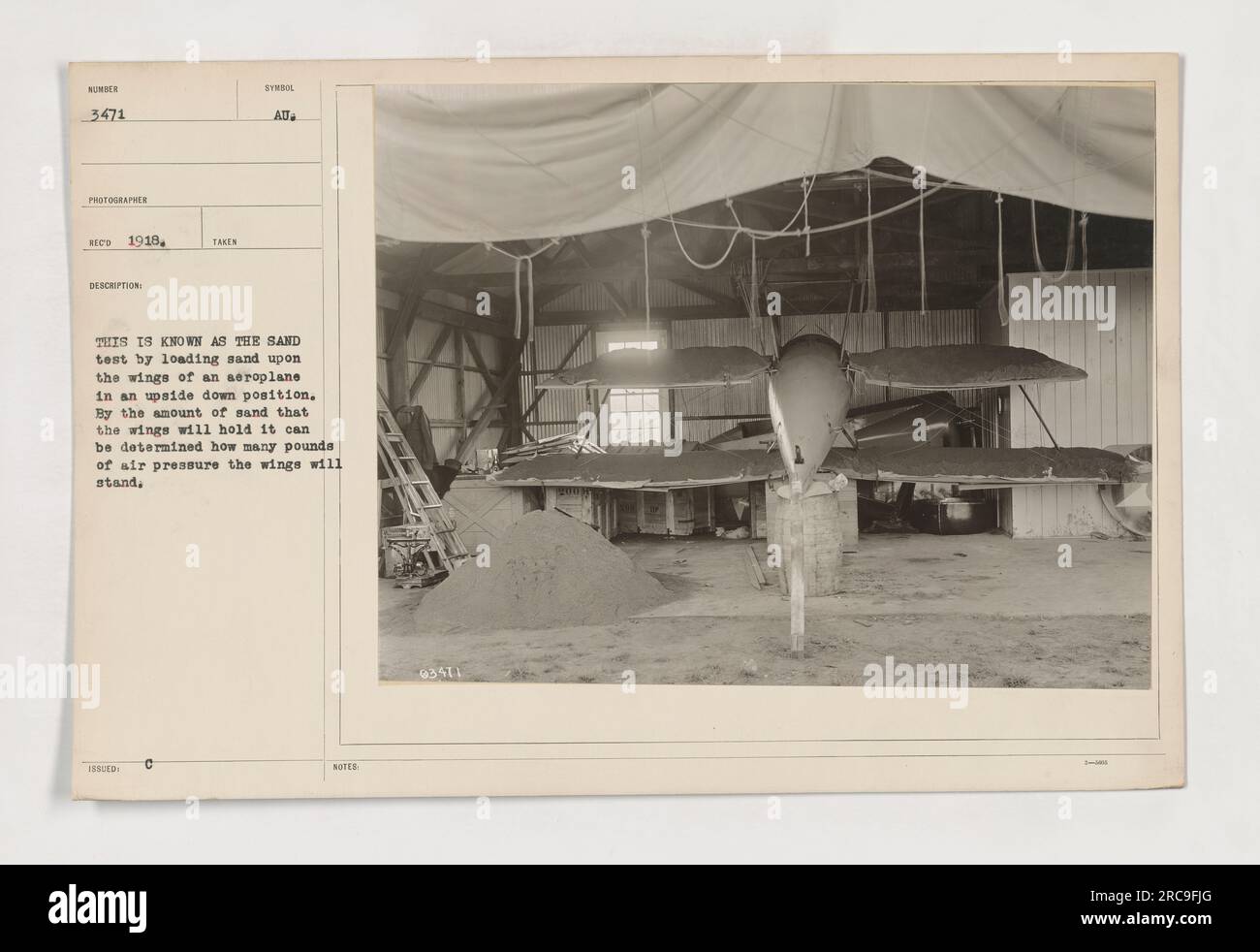 Auf diesem Foto wird während des Ersten Weltkriegs ein Sandtest in einem Flugzeug durchgeführt Die Flügel des Flugzeugs stehen auf dem Kopf, und es wird Sand auf sie geladen. Dieser Test hilft bei der Bestimmung des Luftdrucks, dem die Flügel standhalten können, basierend auf der Menge Sand, die sie halten. Stockfoto
