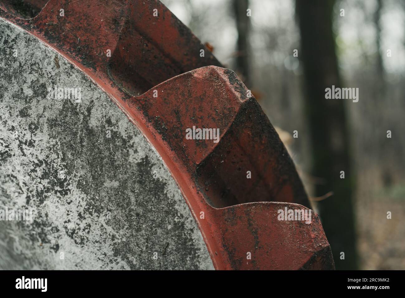 Detail einer alten, unbenutzten gigantischen roten Ausrüstung im Wald. Industrielle Geschichtsmaschine. Nahaufnahme einer verlassenen Maschine. Eisen- und Stahlproduktion. Stockfoto