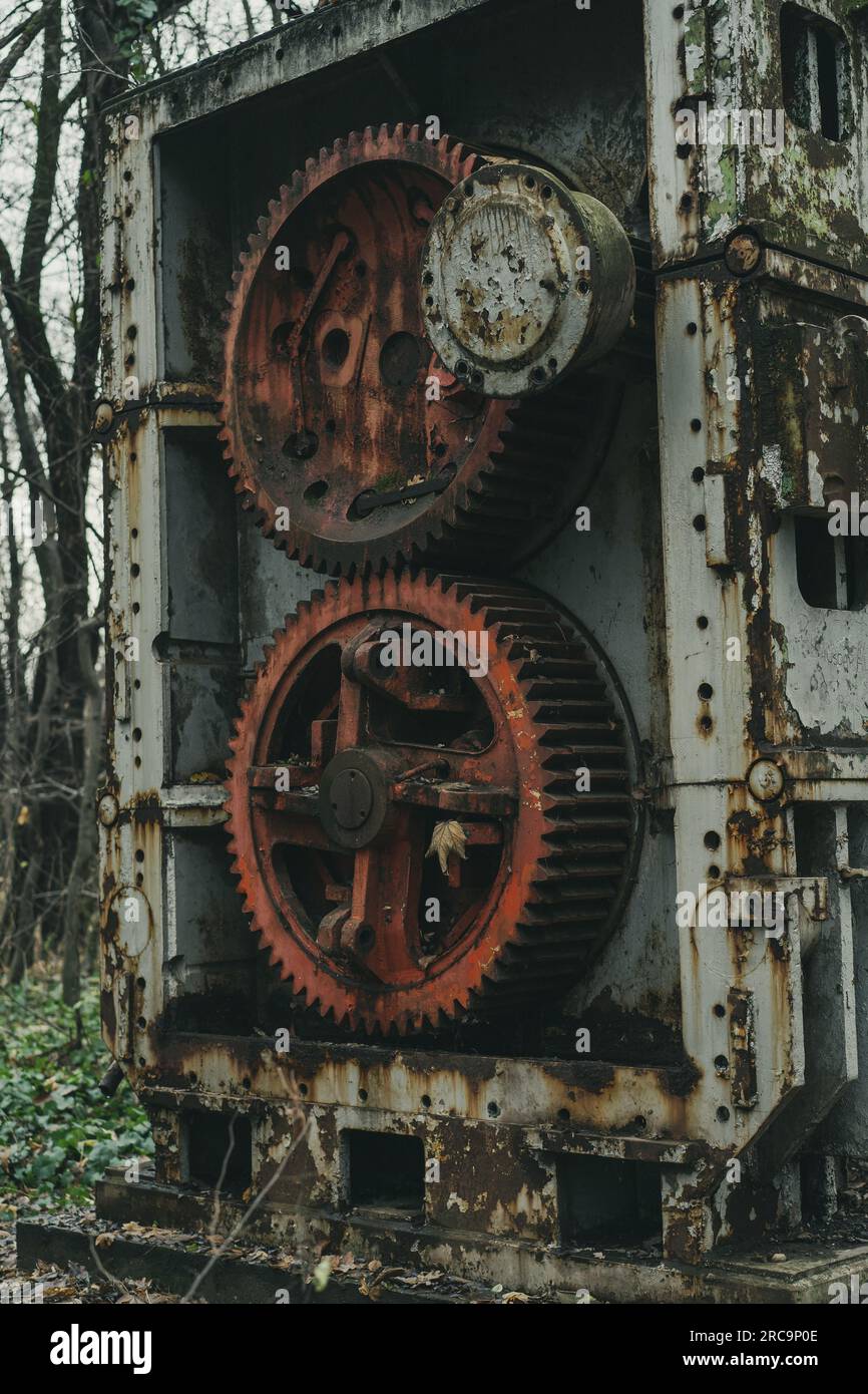 Eine alte, veraltete Blechbearbeitungsmaschine im Wald. Eisen- und Stahlproduktion. Industrielle Geschichtsmaschine. Stockfoto