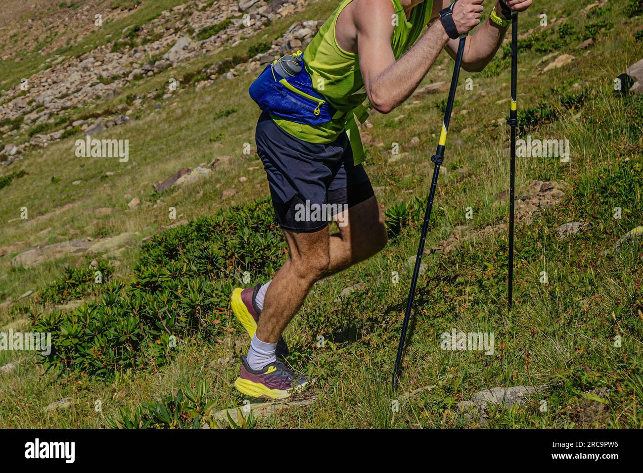 Mann mit Wanderstöcken steil bergauf beim Mountain Marathon Race Stockfoto