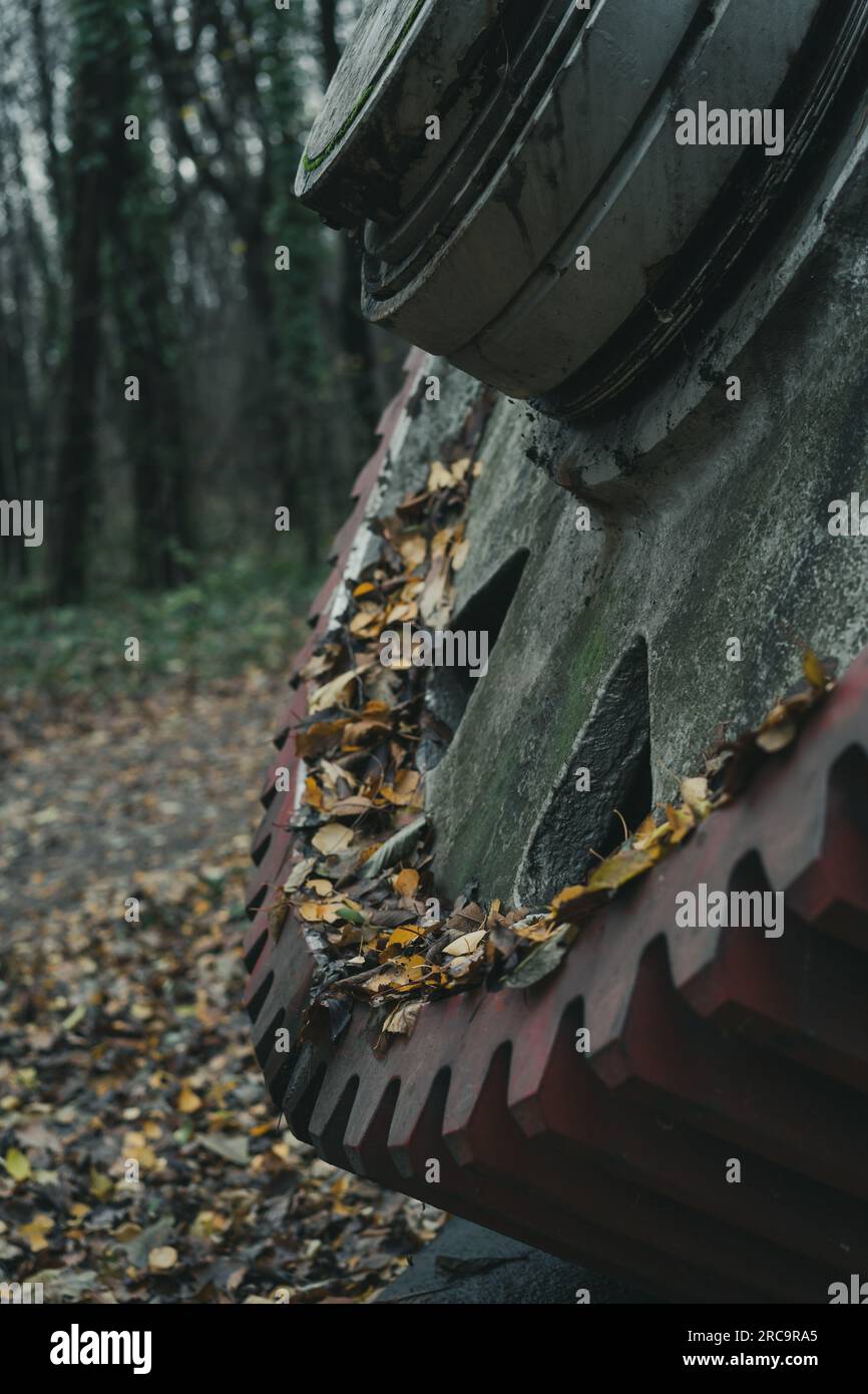 Detail einer alten großen roten Ausrüstung im Herbst im Wald. Industrielle Geschichtsmaschine. Verlassene Maschine. Eisen- und Stahlproduktion. Stockfoto