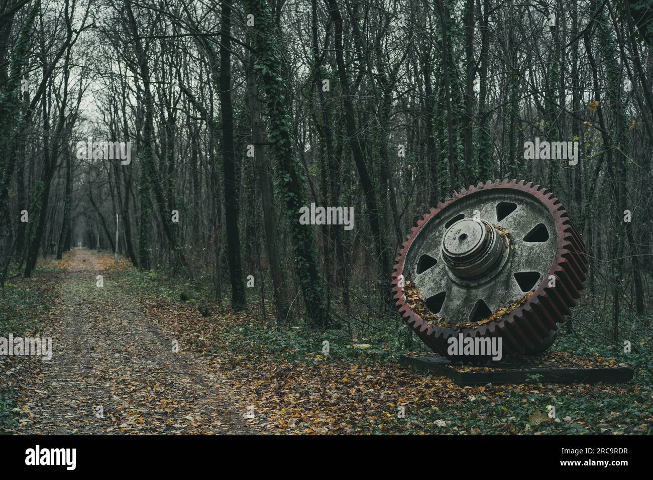 Eine alte, unbenutzte gigantische Ausrüstung im Wald entlang der Straße. Industrielle Geschichtsmaschine. Verlassene Maschine. Eisen- und Stahlproduktion. Stockfoto