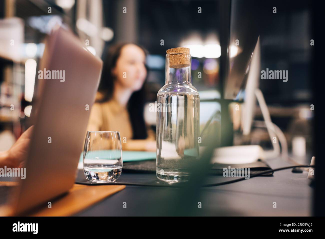 Wasserflasche und Glas auf dem Schreibtisch im Büro Stockfoto