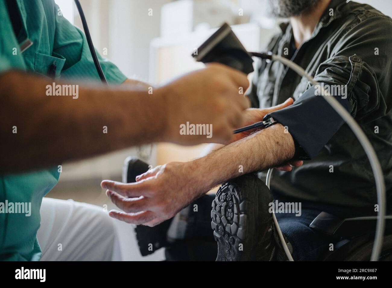 Arzt-Blutdruckkontrolle bei Behinderten in der Klinik Stockfoto
