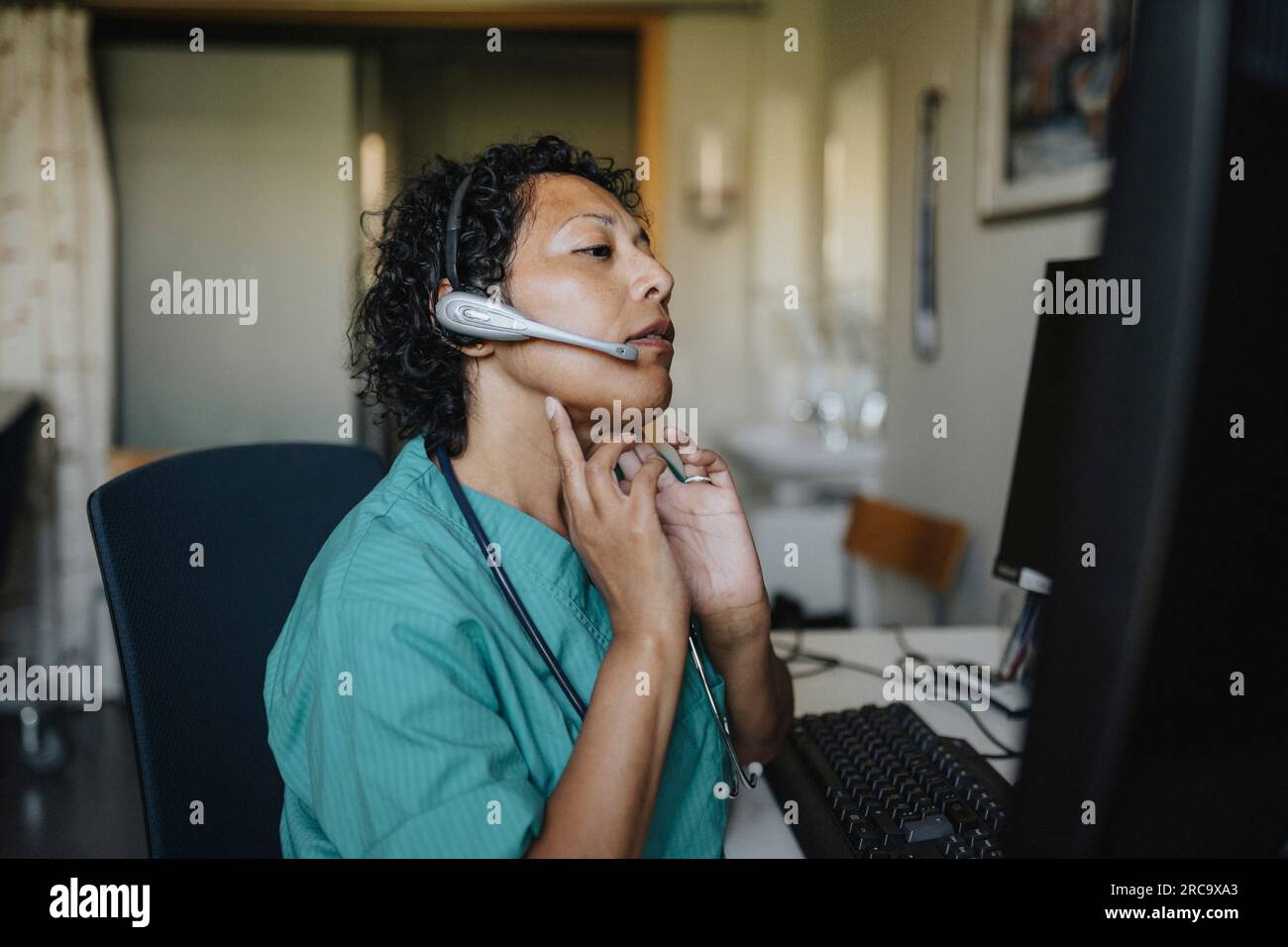 Arztin, die im Krankenhaus durch Videoanruf Ratschläge erteilt Stockfoto