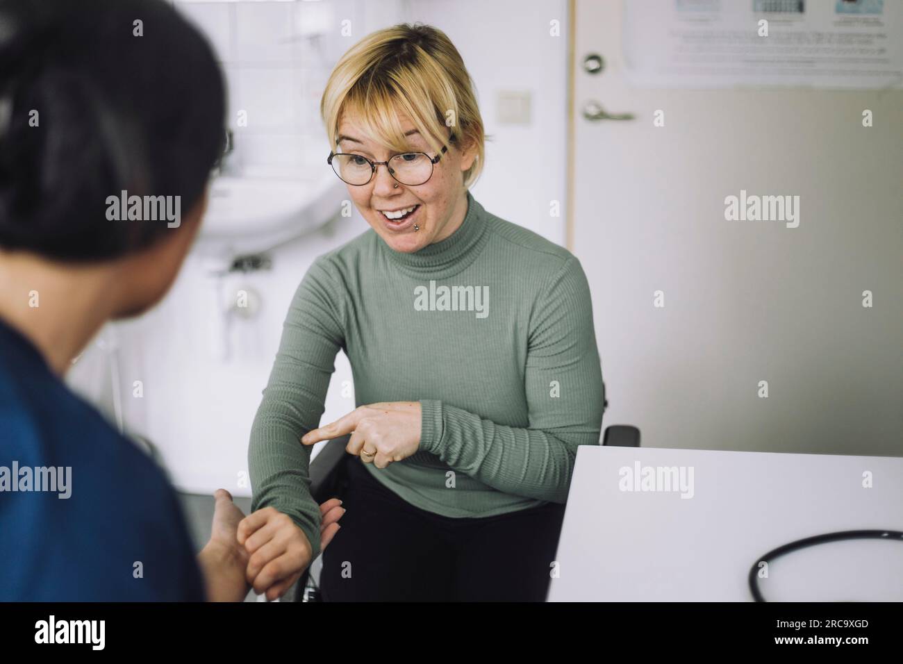 Behinderte Frau bei Spitalbesuch mit Krankenschwester Stockfoto