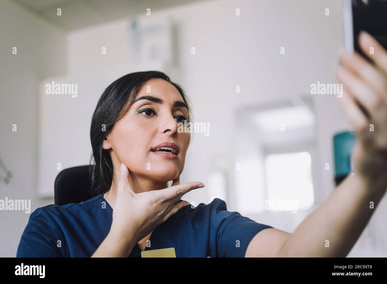 Eine Krankenschwester, die im Krankenhaus eine Online-Beratung über Smartphone durchführt Stockfoto