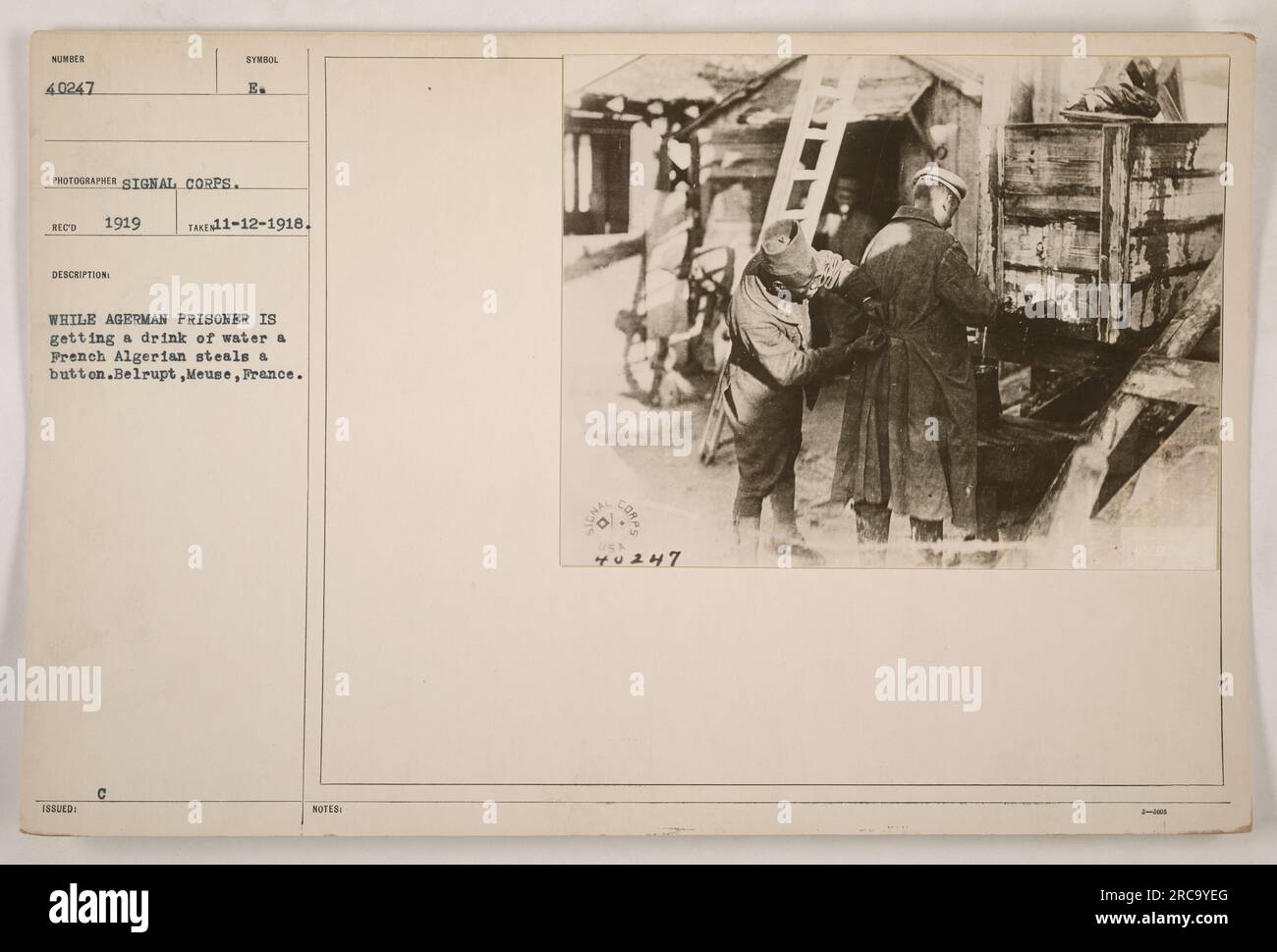Ein deutscher Gefangener trinkt Wasser, während ein französischer algerischer Soldat einen Knopf stiehlt. Standort: Belrupt, Mause, Frankreich. Datum: 12. November 1918. Foto aufgenommen vom Fotografen des Signalkorps, rot 1919. Ausgestellt in: Symbol C B. Stockfoto