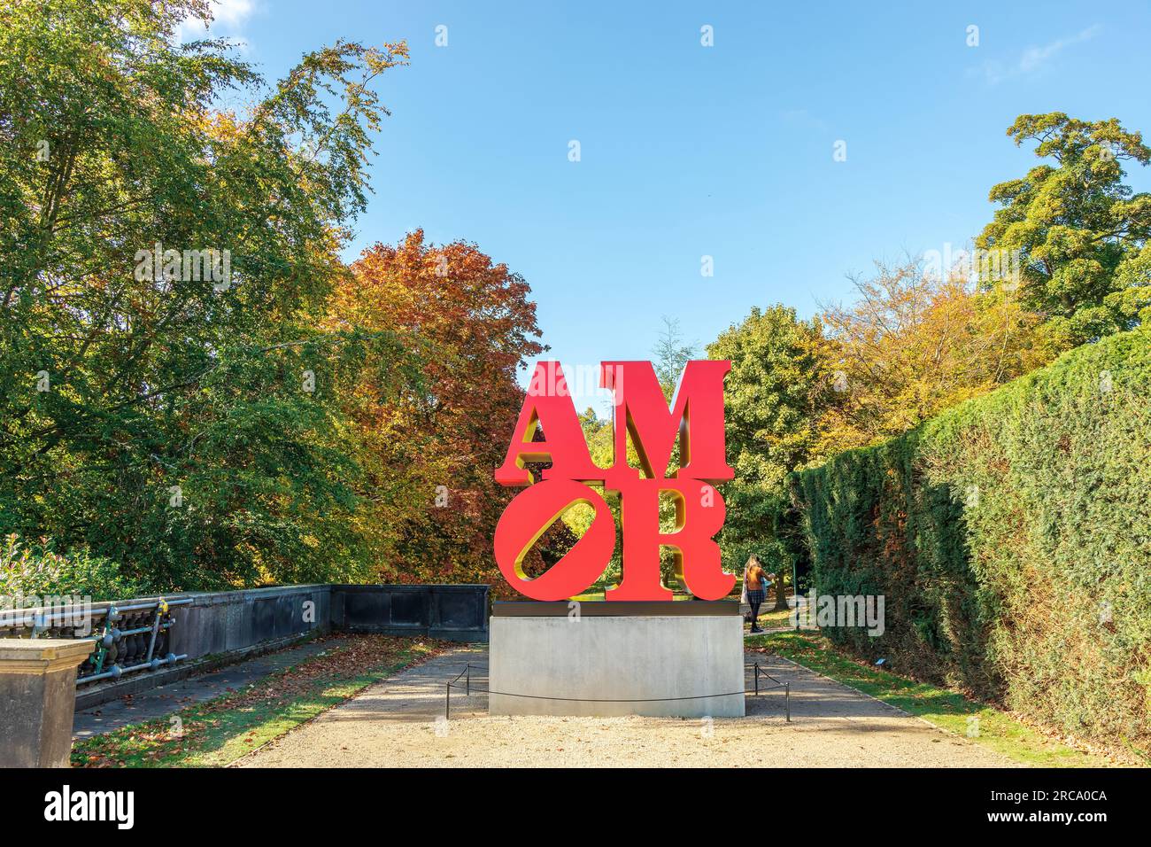 Installationsansicht der Skulptur Amor - Rot Gelb des amerikanischen Künstlers Robert Indiana, die auf dem YSP bei Wakefield, Großbritannien, ausgestellt wurde. Stockfoto